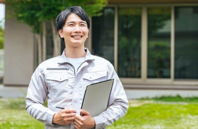 笑顔で住宅の前に立つ男性作業員